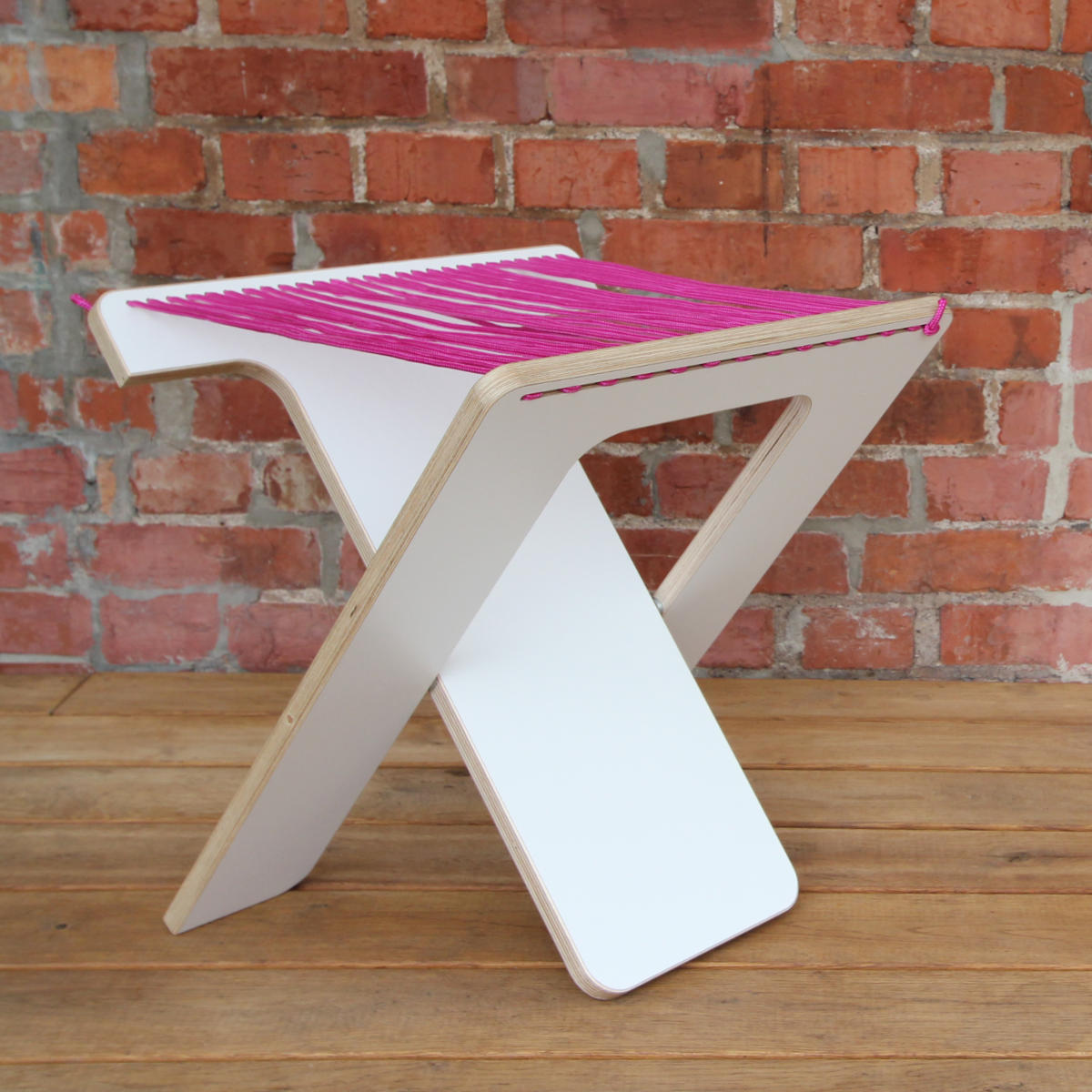 WILJA Klapphocker Karl faltbar aus Holz mit Seil in pink auf Terrasse schraeg