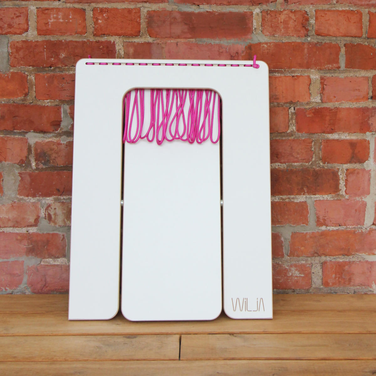 WILJA Klapphocker Karl faltbar aus Holz mit Seil in pink auf Terrasse zusammengeklappt